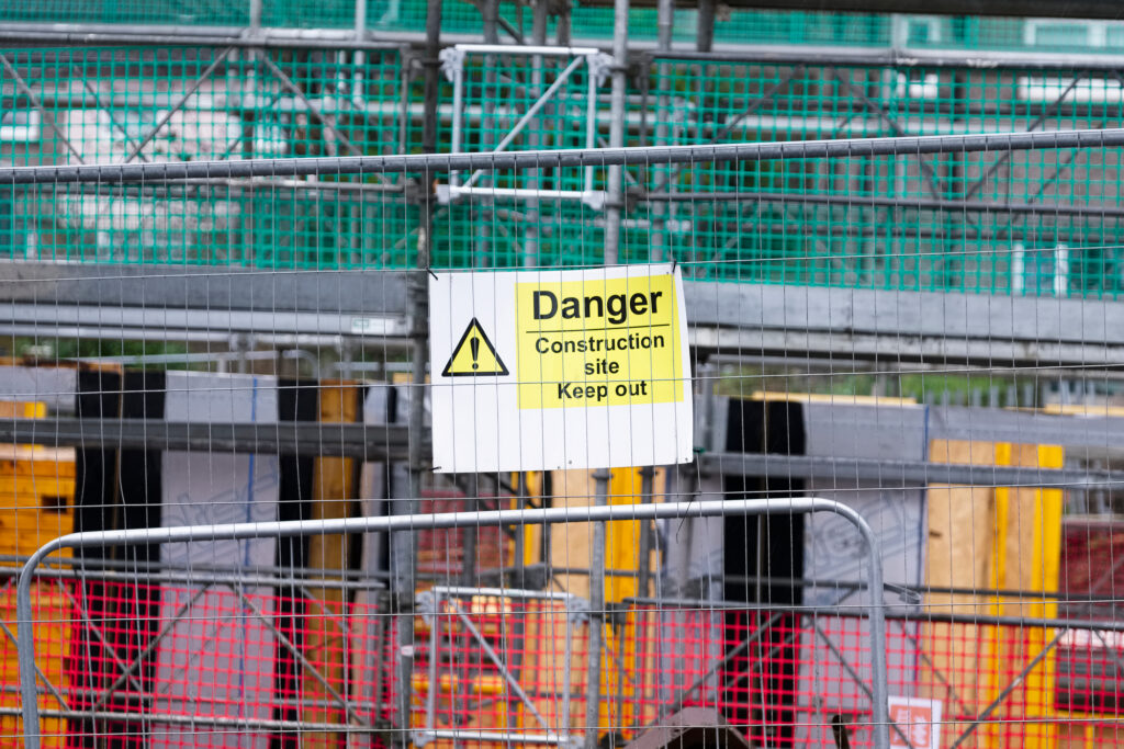 Why the 'First 10 Feet' of Your Construction Site Perimeter Security Rules Criminal Behavior Danger sign on a construction site fence
